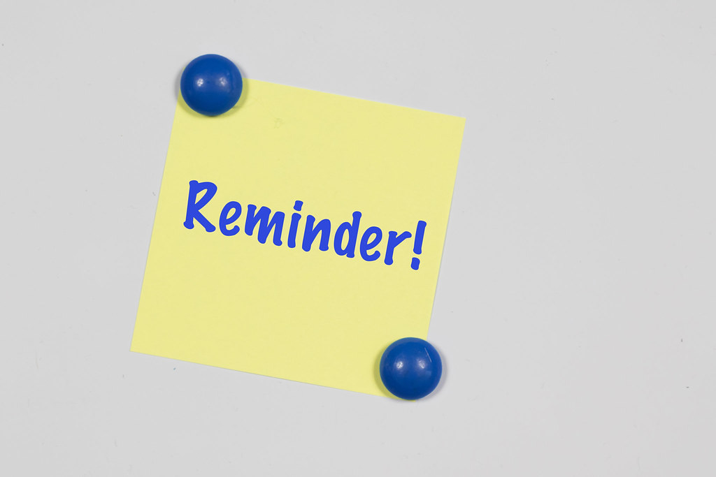 The word "Reminder" written on a yellow sticky note